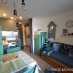 Slide Salon ouvert sur une cuisine avec canapé lit gigogne dans les studios de Valfréjus