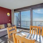 Slide Living area with a dining space and TV, opening onto a balcony with mountain views at Les Terrasses de Veret apartments in Flaine
