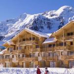 Slide Exterior view of Le Parc des Airelles residence covered in snow, with direct access to the ski slopes