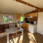 Slide Interieur d'un mobil home avec coin salon et cuisine au domaine de lambon