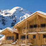Slide Exterior view of Le Parc des Airelles residence covered in snow, with direct access to the ski slopes