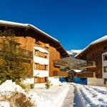 Slide Exterior view of Les Fermes de Samoens residence with sunshine and snow