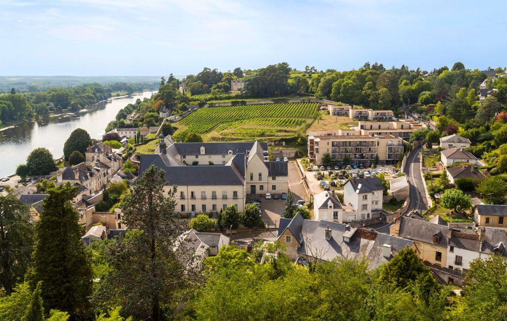 Slide Vue aérienne de la résidence Le Clos Saint-Michel à Chinon, entourée de vignobles et du Val de Loire