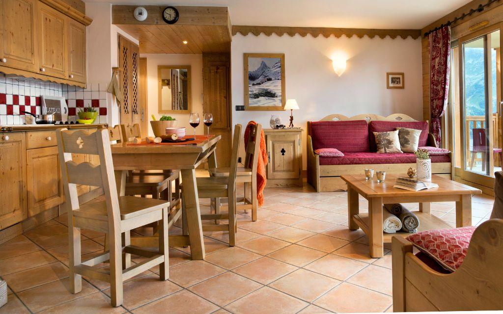 Slide Intérieur d’un appartement chaleureux à la résidence Le Cœur d’Or à Bourg-Saint-Maurice, avec salon, coin repas et cuisine équipée