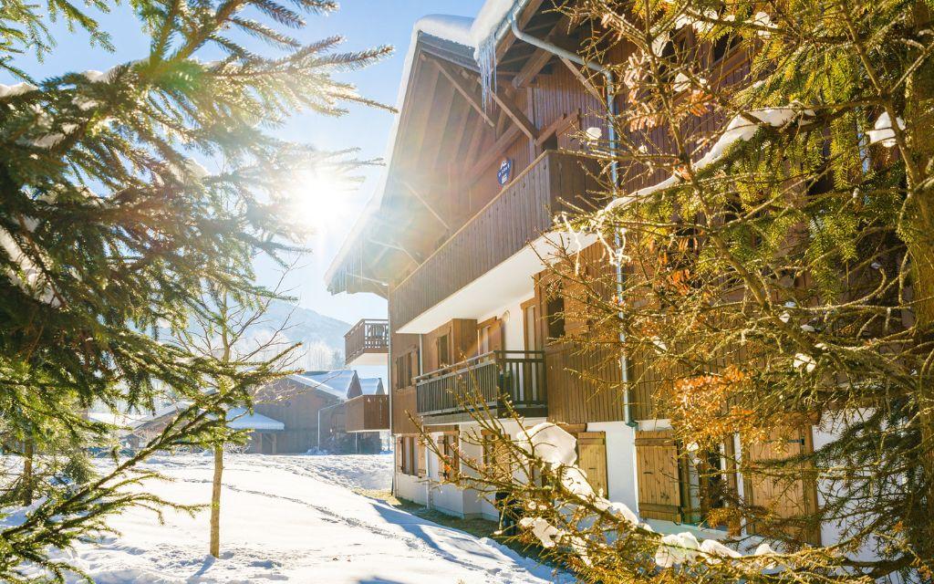 Slide Extérieur des chalets enneigés aux Fermes de Samoëns by Ateya Vacances