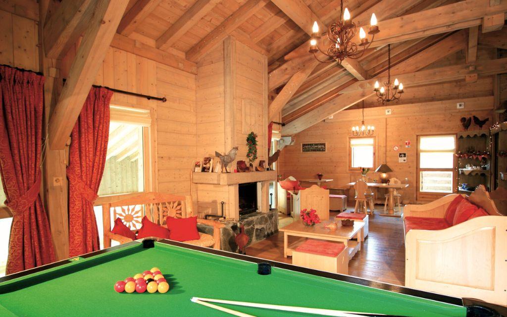 Slide Grande salle conviviale avec billard et cheminée en pierre aux Fermes de Samoëns by Ateya.