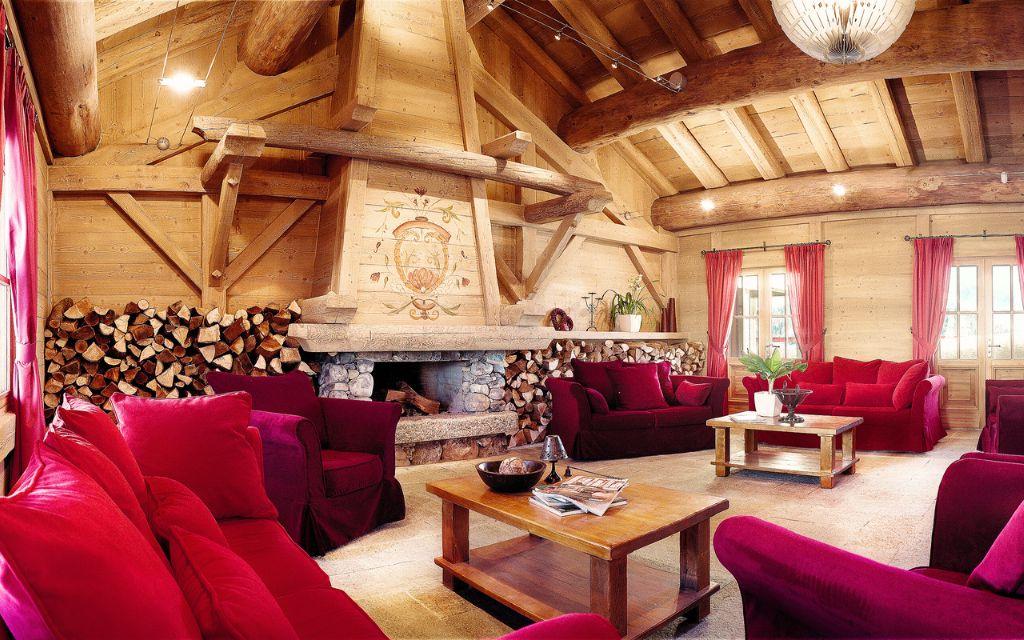 Slide Salon chaleureux avec cheminée et canapés confortables à la résidence Le Hameau du Beaufortain aux Saisies