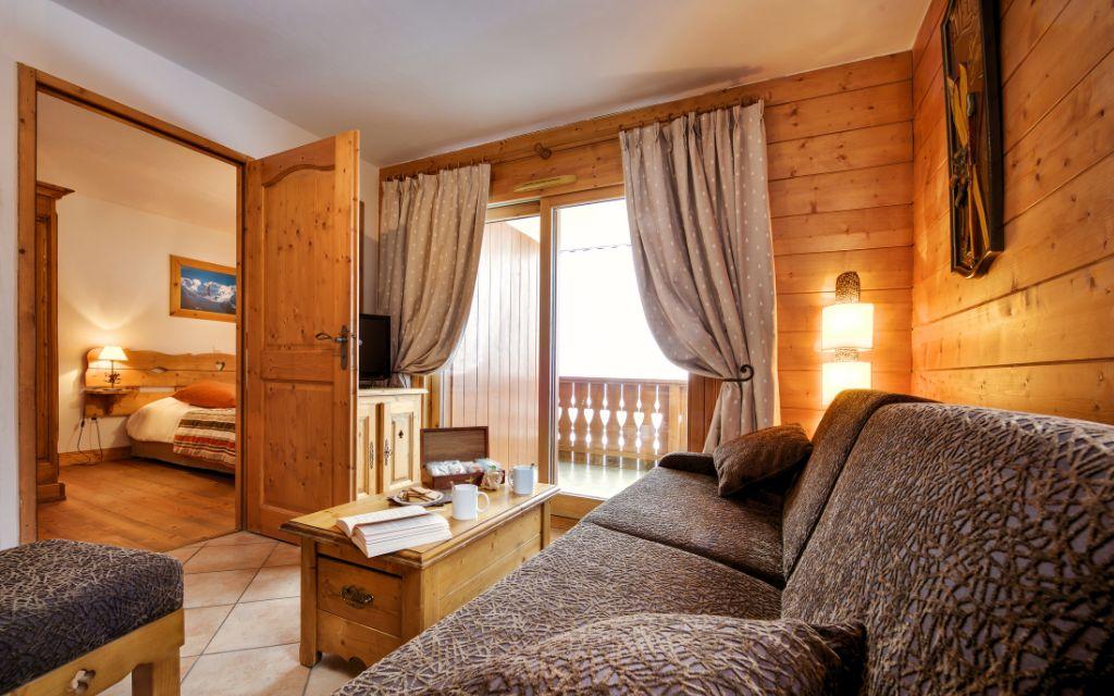 Slide Salon avec canapé et accès à une chambre au Hameau du Beaufortain aux Saisies