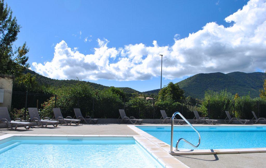 Slide Swimming pool overlooking the village of Montbrun at the Le Hameau des Sources residence