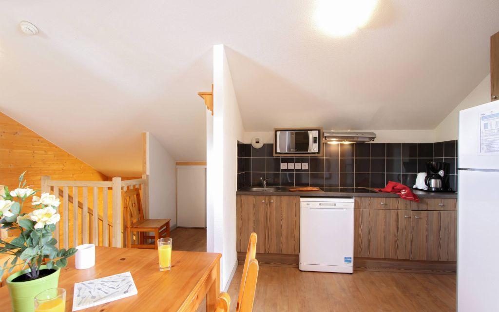 Slide Fully equipped kitchen area opening onto the living room of a duplex apartment in the Ours Blanc residence