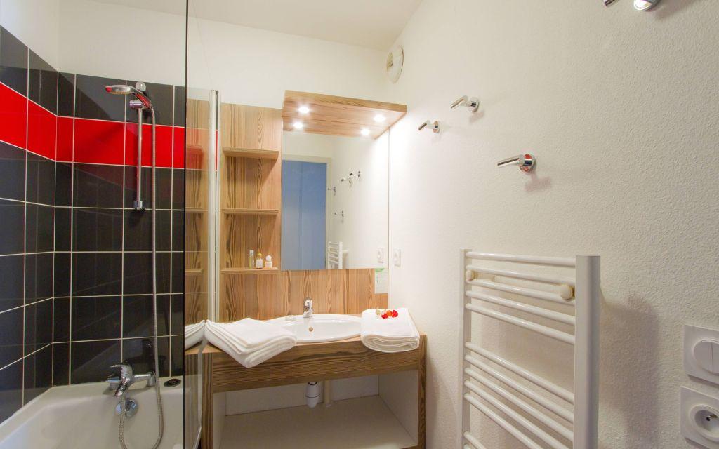 Slide Bathroom with bathtub and towel dryer in an apartment at the Résidence l'Ours Blanc in Les Deux Alpes