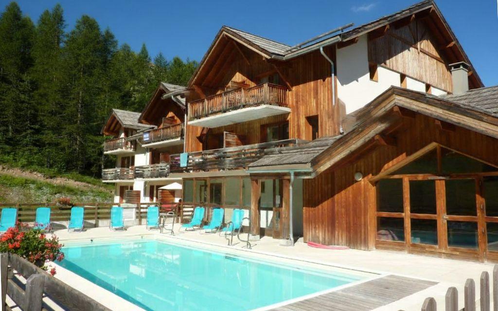 Slide Overview of La Combe d'Or residence in Les Orres 1800 under the sun with swimming pool