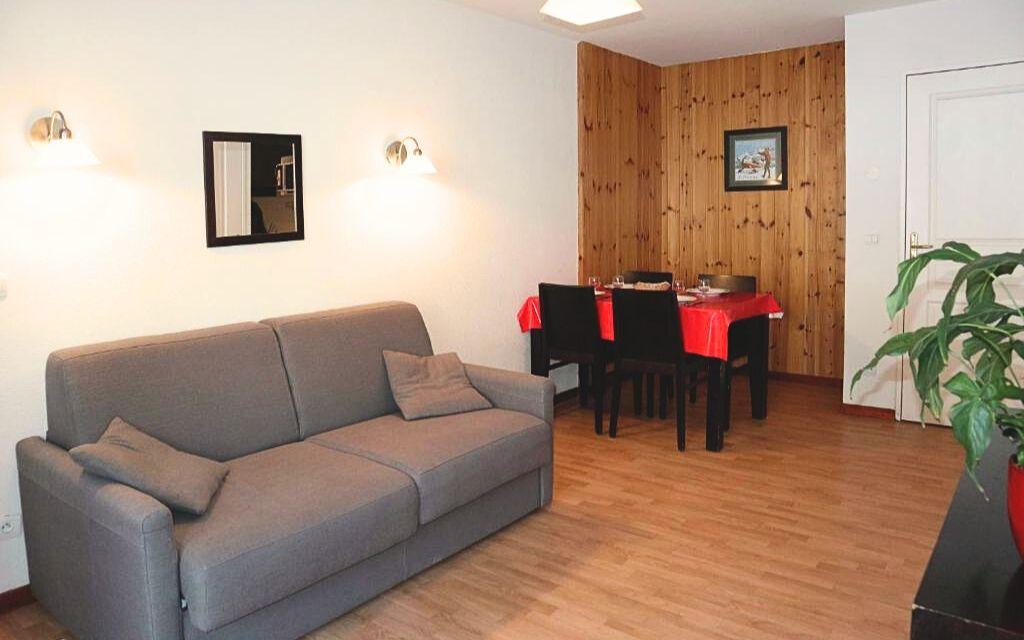 Slide Stay in an apartment at La Combe d'Or residence in Les Orres 1800 with sofa and dining table
