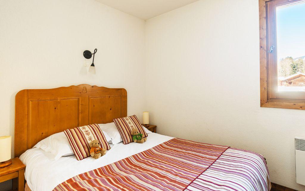 Slide room with a double bed for 2 people and a window overlooking the mountains at Les Fermes de Samoens residence