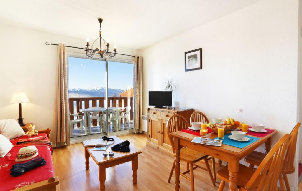 Slide living room with sofa and dining table, mountain view at Les Chalets du Belveder residence