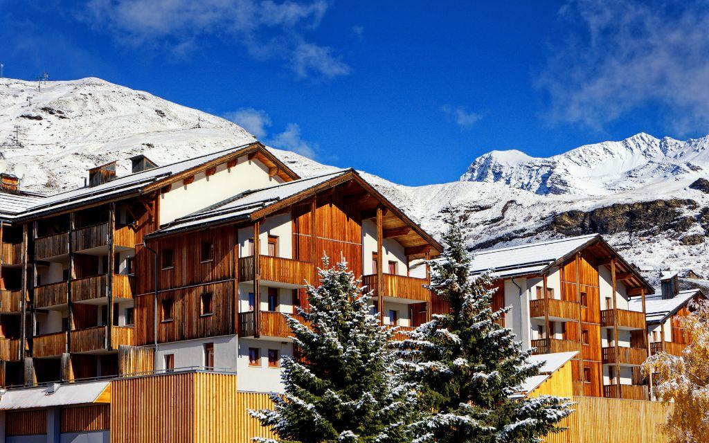 Slide Résidence Les Etoiles d'Orion composée de batiments en bois et recouvert de neige