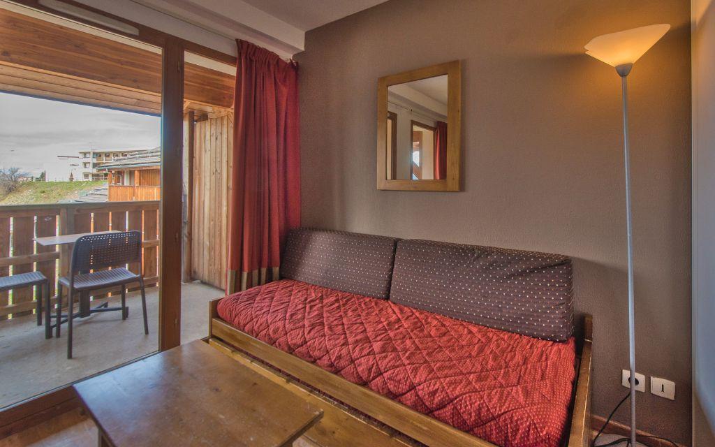 Slide Salon avec canapé-lit et fenêtre qui donne sur le balcon avec la vue montagne