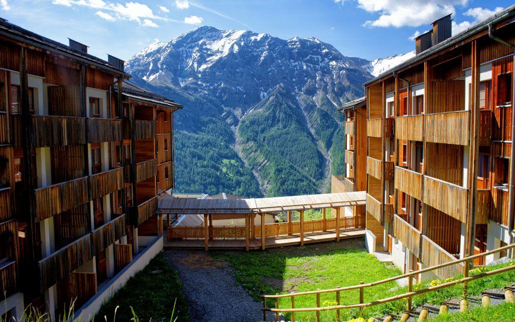 Slide View of the Les Etoiles d'Orion residence in the mountains surrounding it in summer