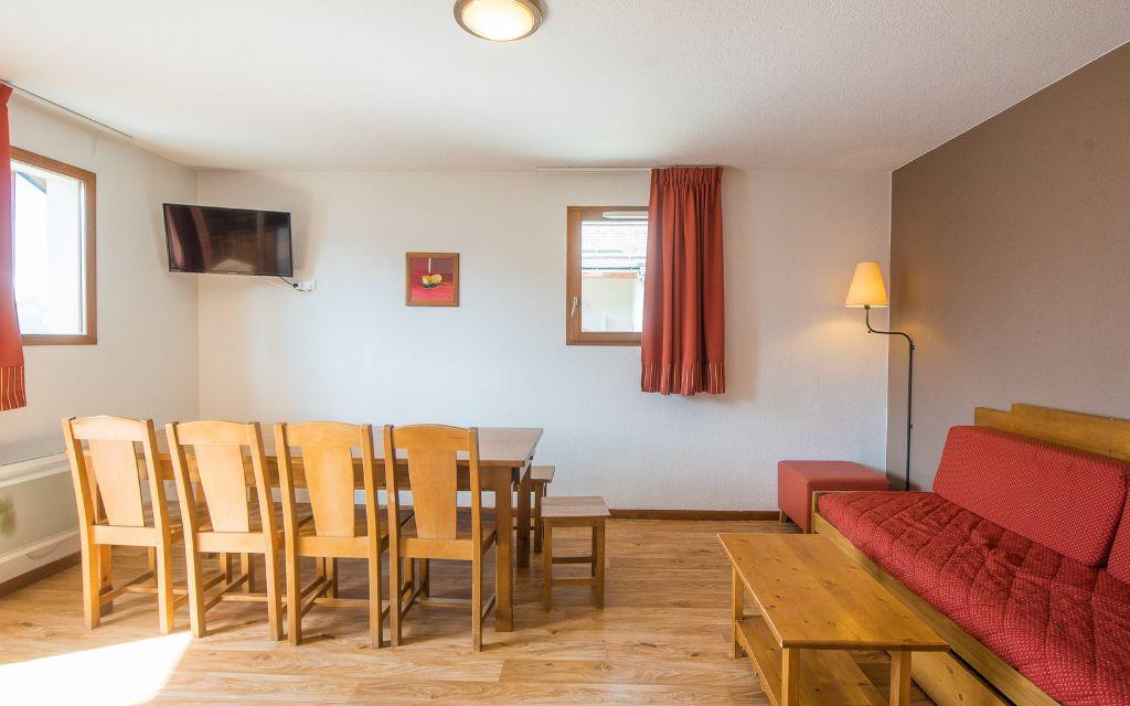 Slide Living room with television, table for a large family and sofa in the Les Etoiles d'Orion residence