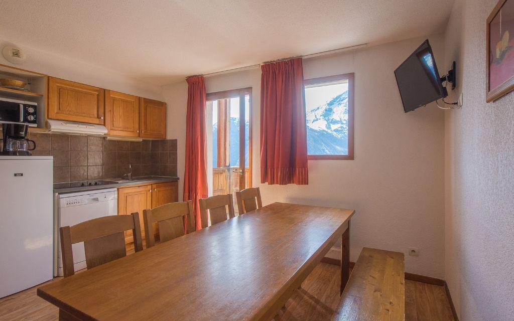 Slide Fully equipped kitchen opening onto the dining area in an apartment in the Les Etoiles d'Orion residence