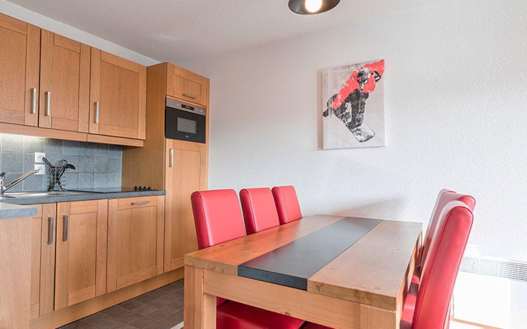 Slide Living area with dining table and open kitchen at the Les Chalets d’Émeraude residence