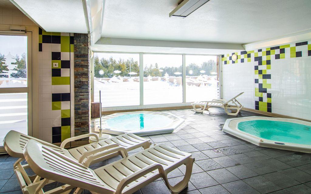 Slide Jacuzzi with lounge chairs within the Pyrénées 2000 residence