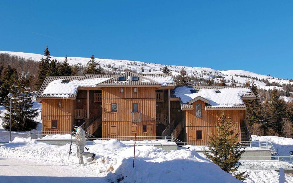 Slide Vue générale de la résidence L’Orée des Pistes l’hiver sous la neige