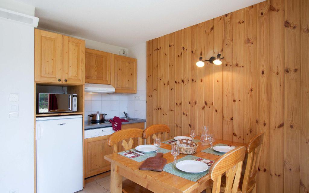 Slide Espace salle à manger avec cuisine ouverte dans un appartement de la résidence L’Orée des Pistes