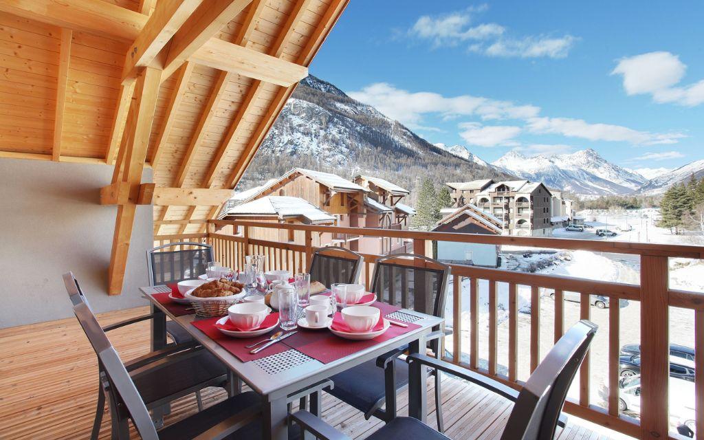 Slide Balcon avec salon de jardin vue sur les montagnes l’hiver à Serre Chevalier
