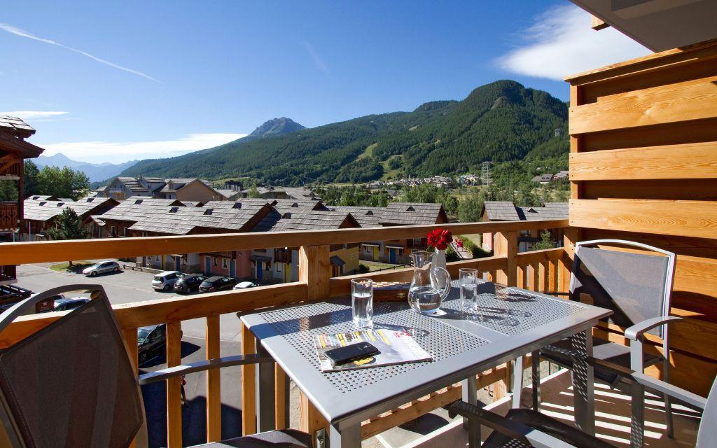Slide Balcony with garden furniture and mountain view in summer at Serre Chevalier