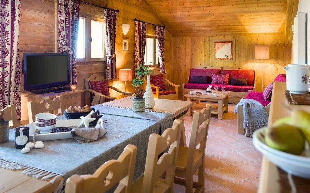 Slide Séjour avec coin repas et canapé dans un appartement de la résidence Les Chalets de Lessy