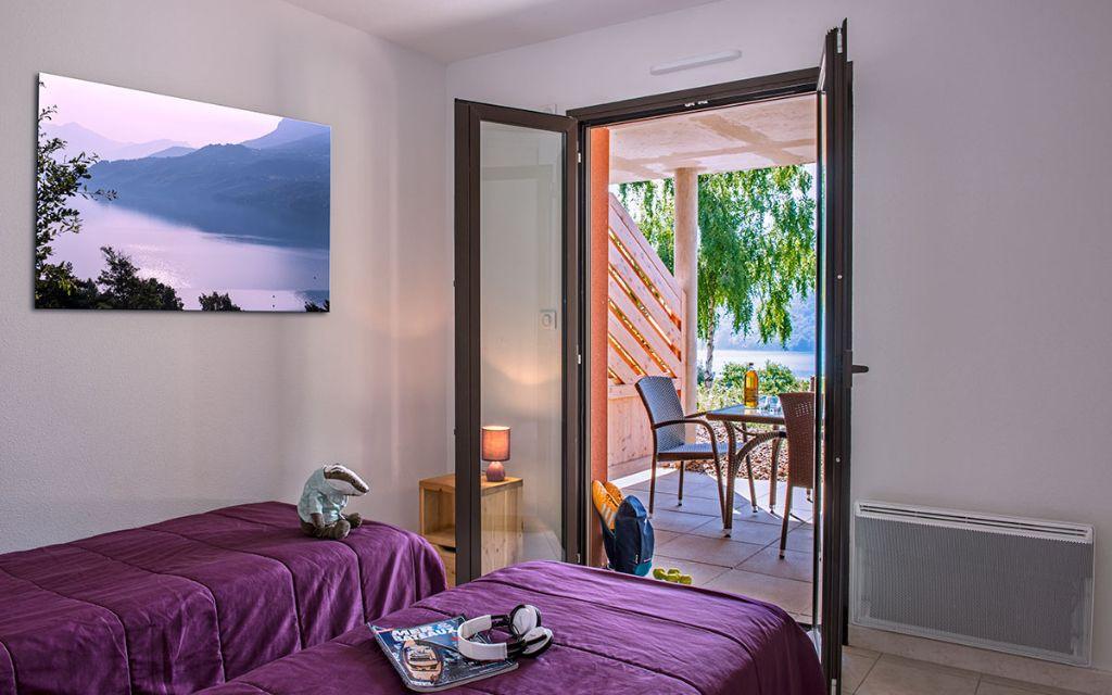 Slide Two single beds with access to a terrace at L’Écrin du Lac