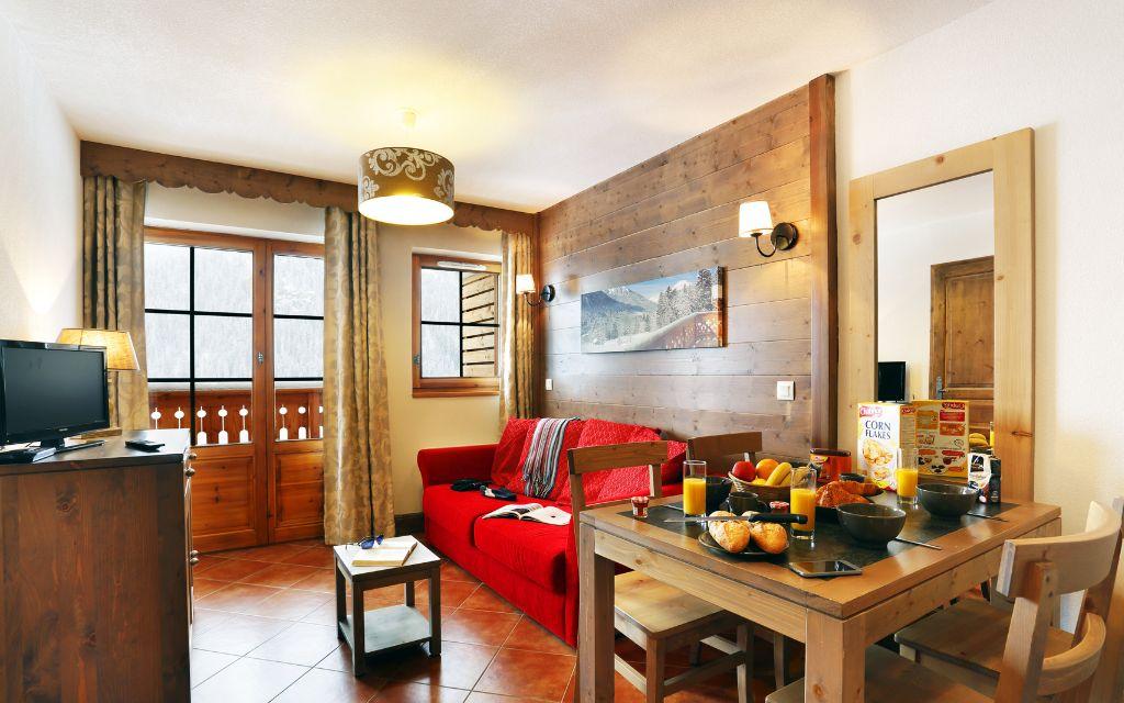 Slide Vue globale sur le séjour composé d’un espace salon, d’une table à manger et d’un aperçu de la chambre au Grand Lodge de Châtel