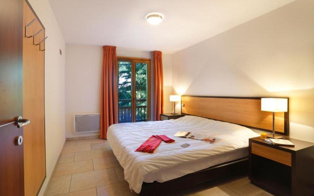 Slide Chambre double avec tables de chevets dans la résidence et fenêtre donnant sur les montagnes à Châtel