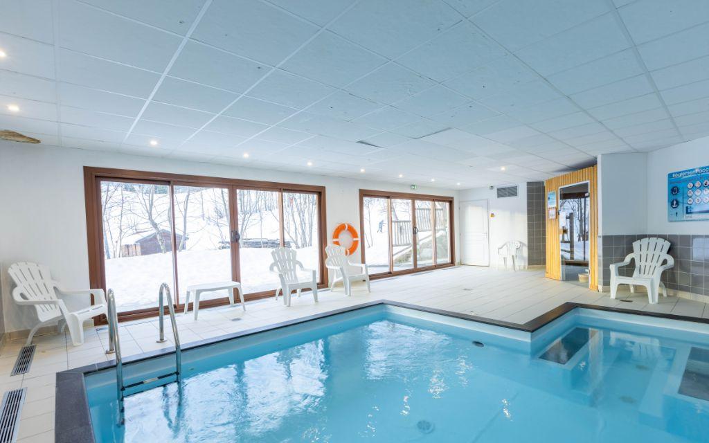 Slide Piscine intérieure dans la résidence Les Bottières avec vue sur les montagnes enneigées