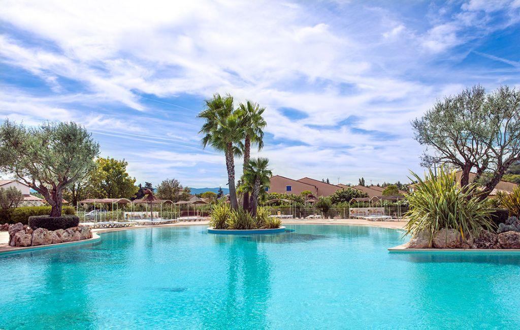 Slide Grande piscine extérieure avec transats au sein de la résidence le clos des oliviers