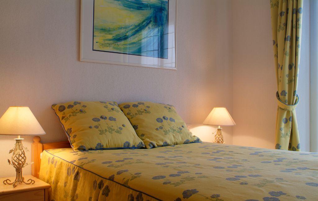 Slide Chambre double avec table de chevets et lampes dans une maison de la résidence le clos des oliviers