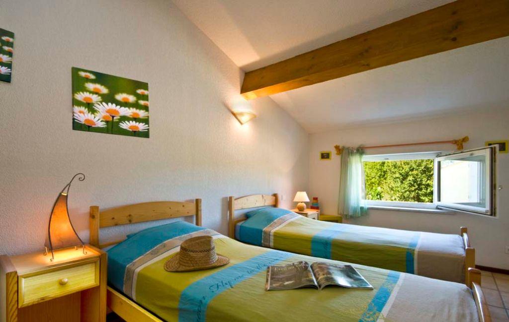 Slide Chambre avec deux lits simples et fenêtre à l’étage d’une maison de la résidence le clos des oliviers