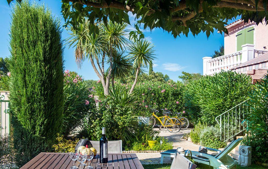 Slide Jardin avec salon de jardin et transats au sein de la résidence le clos des oliviers