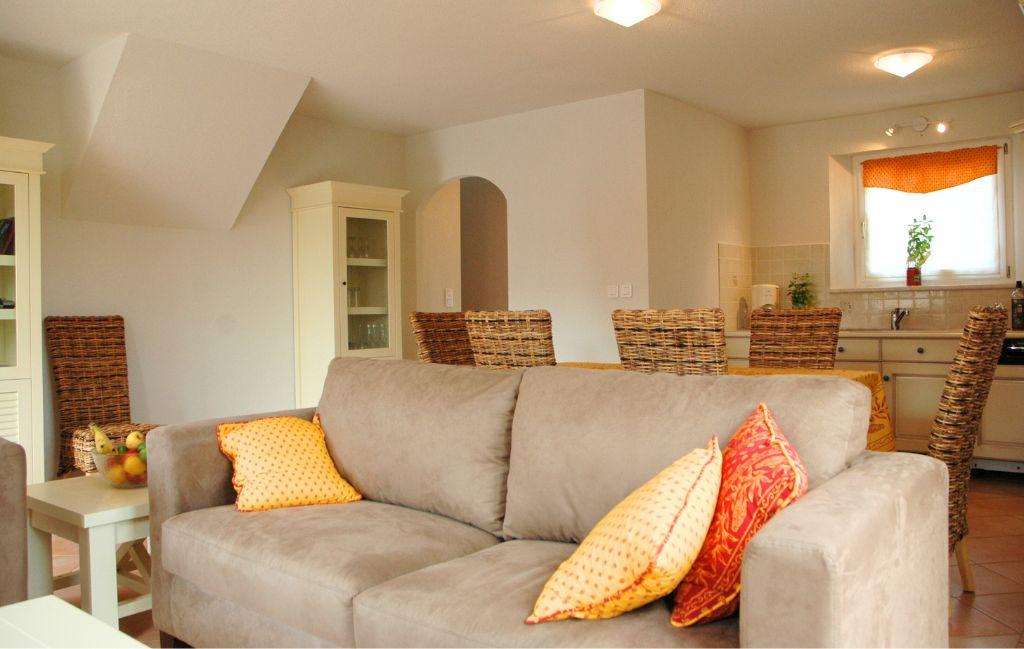 Slide Living room with sofa and dining area behind in a house at Le Clos des Oliviers residence