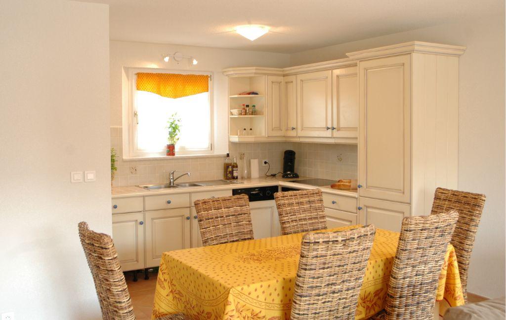 Slide Equipped kitchen open to the dining area in a house at Le Clos des Oliviers residence