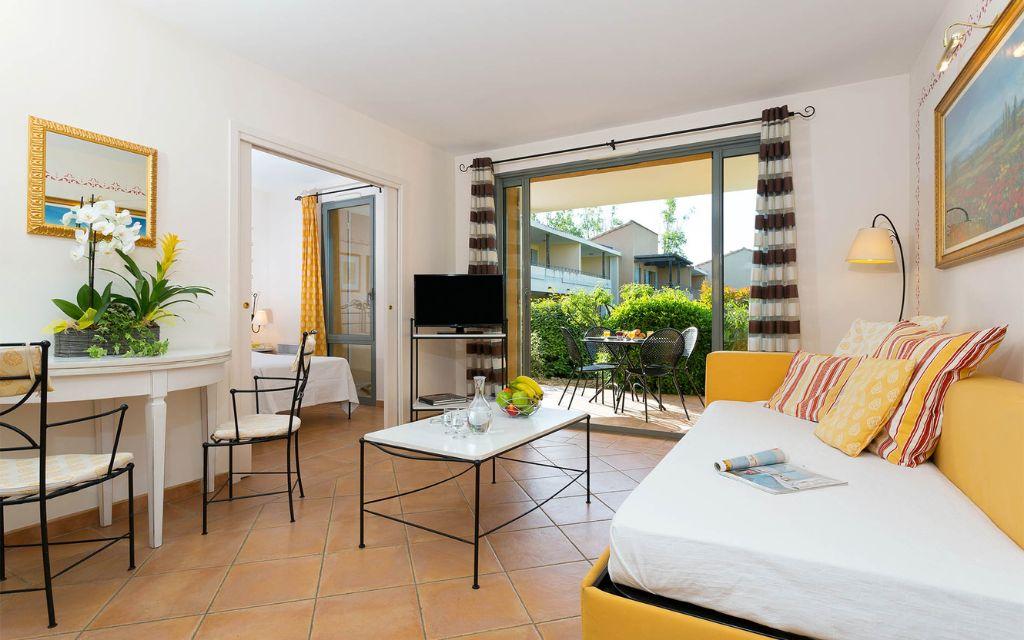 Slide Living room with terracotta floor tiles and view of the golf course from an accommodation unit at the Provence Country Club