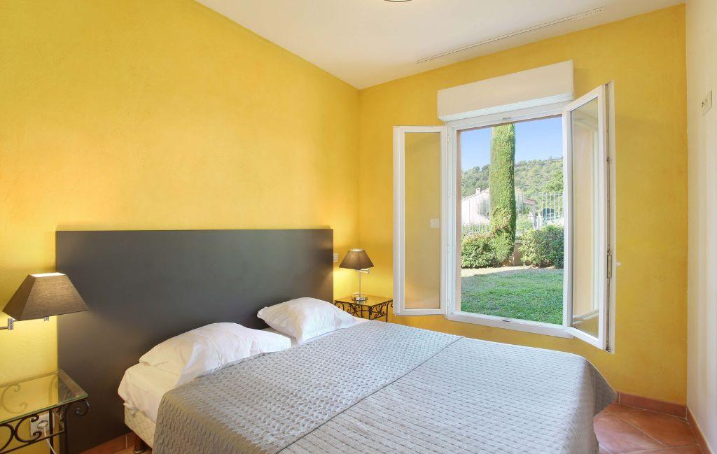 Slide Chambre avec un lit deux personnes et mur jaune dans un appartement de la résidence la licorne de haute Provence