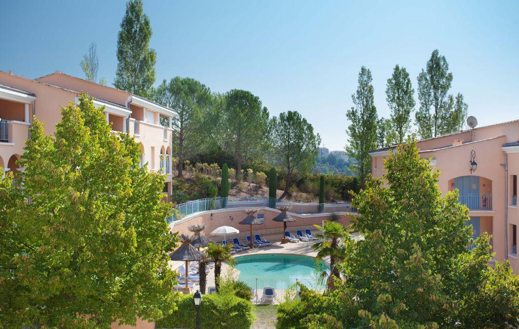 Slide Overall view of the outdoor swimming pool and pine forest in the background at the La Licorne de Haute Provence residence