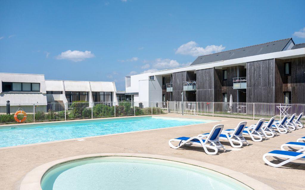 Slide Piscine extérieure avec pataugeoire et transats au sein de la résidence Fleur de Sel