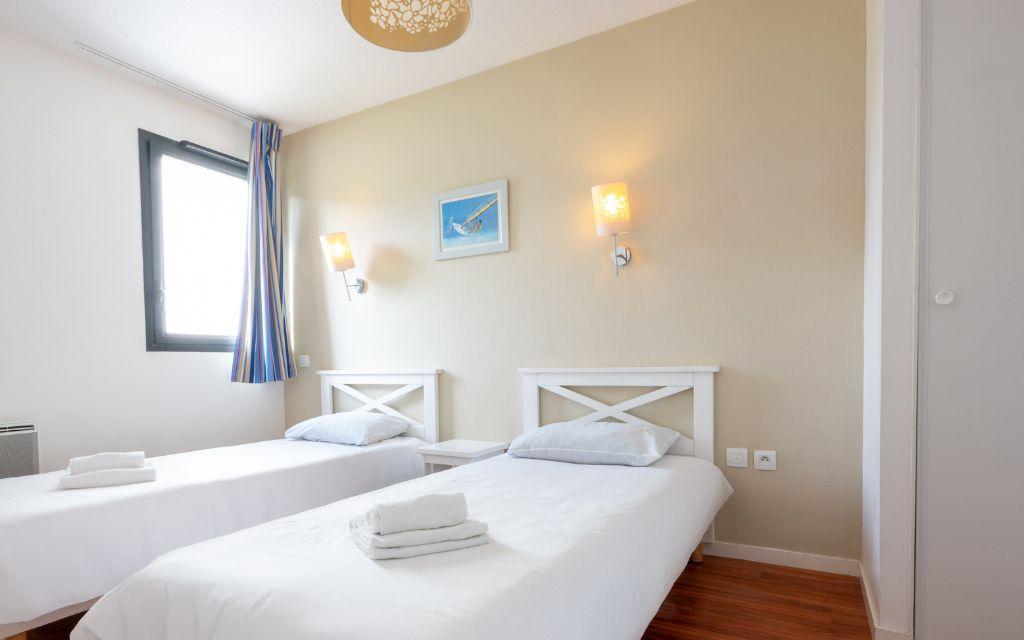 Slide Bedroom with two single beds and towels above in Guidel