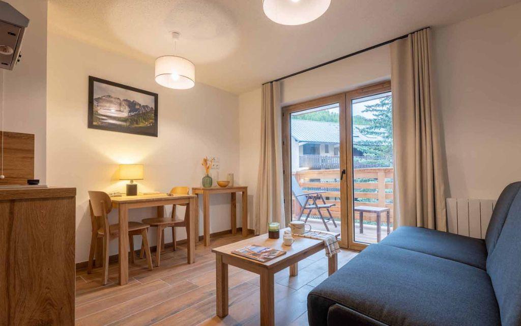 Slide Séjour avec canapé et table au sein d’un studio de la résidence Arya Living Stone