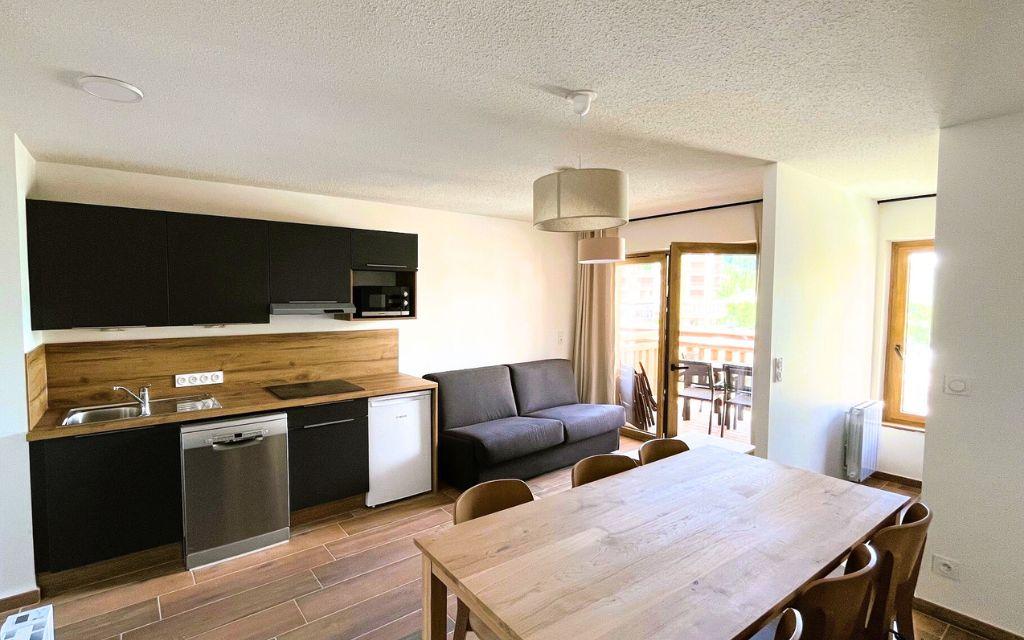 Slide Cuisine ouverte sur le salon et la salle à manger dans un appartement de la résidence Arya Living Stone