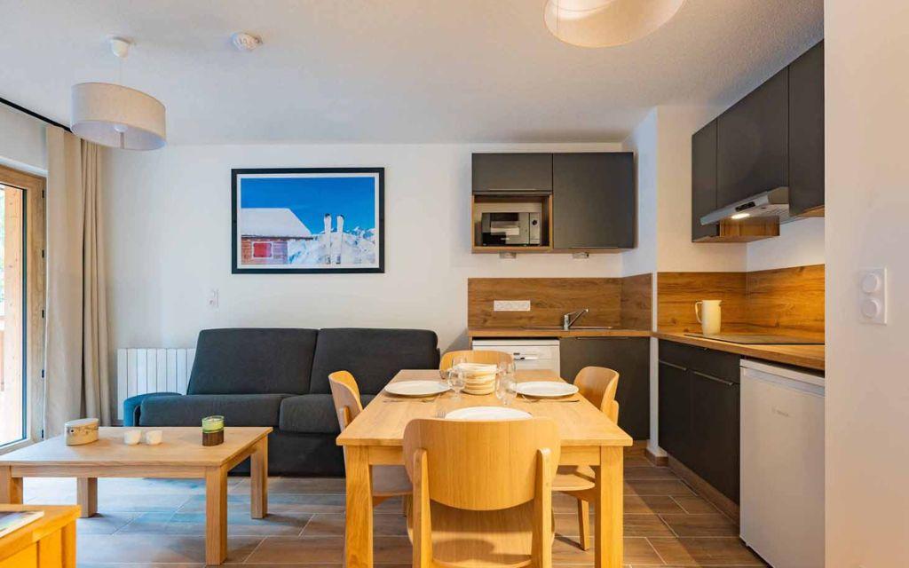 Slide Living room with lounge and dining area in a two-room apartment at the Arya Living Stone residence