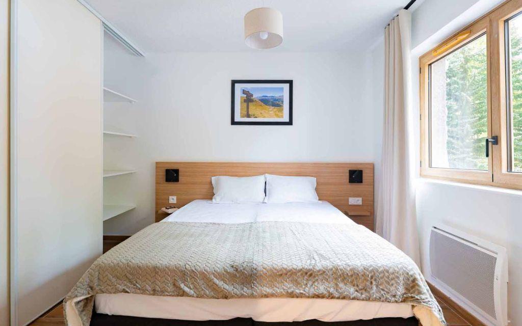 Slide Bright bedroom with a double bed in an apartment at the Arya Living Stone residence